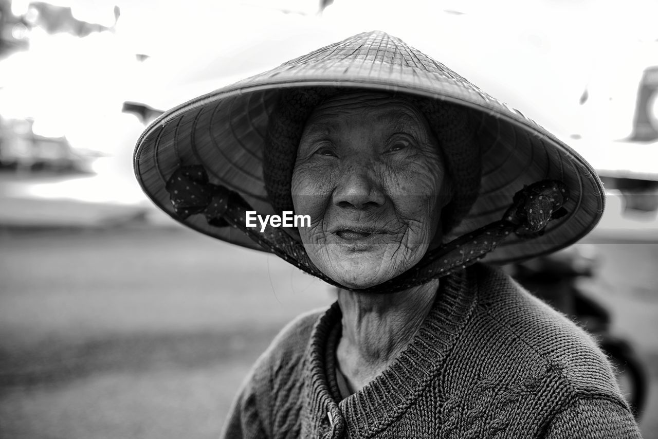 Portrait of senior woman wearing asian style conical hat