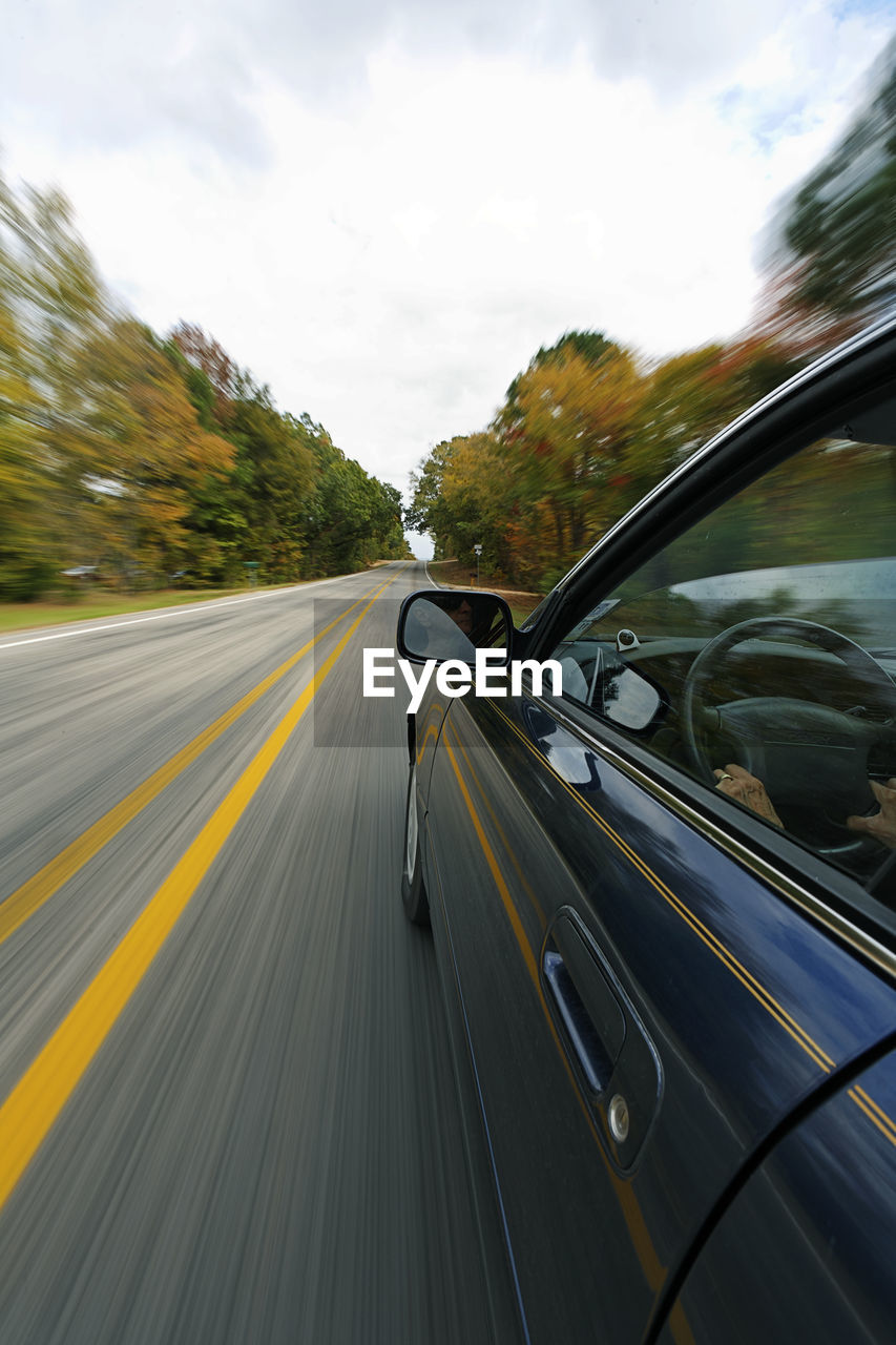 Close-up of car in speed on road against sky