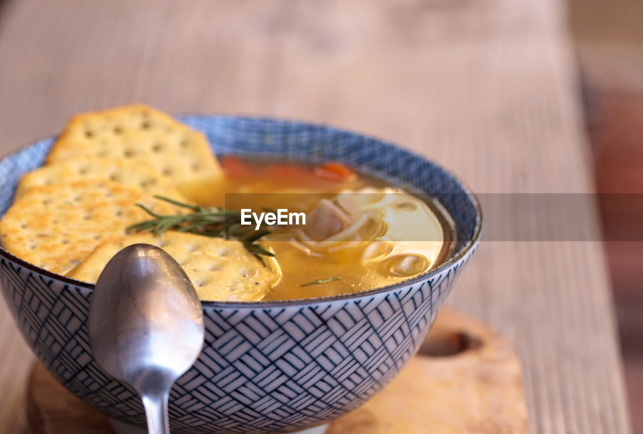 Close-up of soup with crackers on wooden table