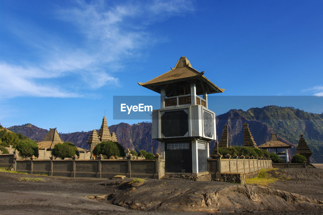 Built structure by mountains against blue sky luhur poten temple bromo tengger semeru national parc