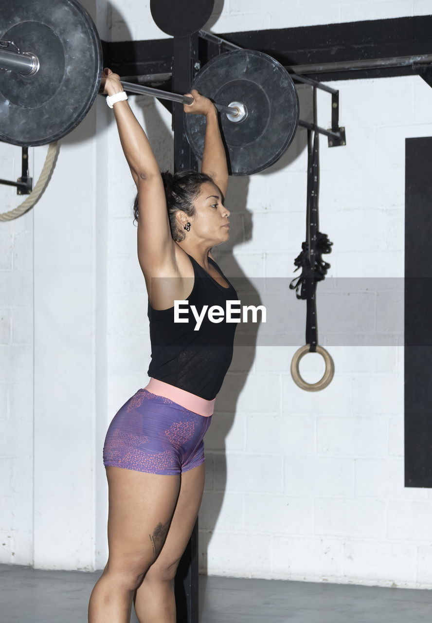 Latin woman working out in a gym lifting weights