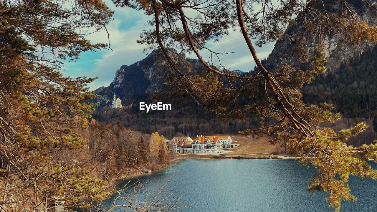 Scenic view of lake against cloudy sky with neuschwanstein castle