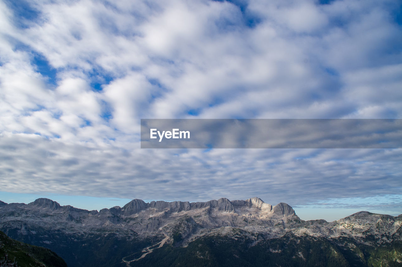 Scenic view of kanin mountain ridge against cloudy blue sky