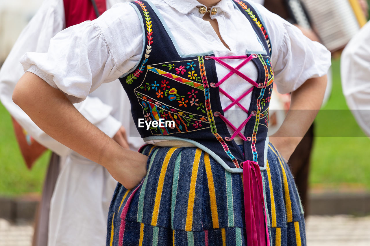 Midsection of woman wearing traditional clothing while standing outdoors