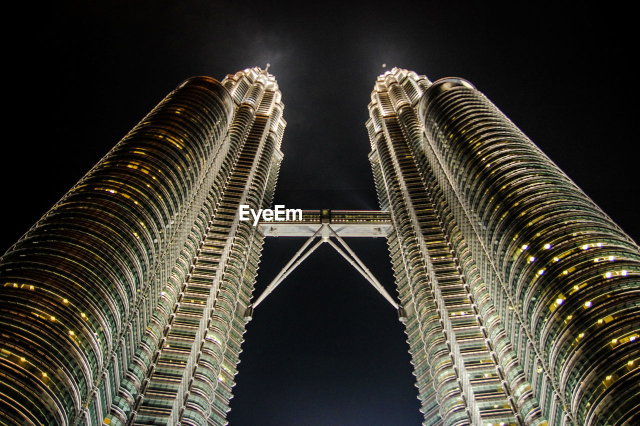 LOW ANGLE VIEW OF ILLUMINATED BUILDINGS AT NIGHT