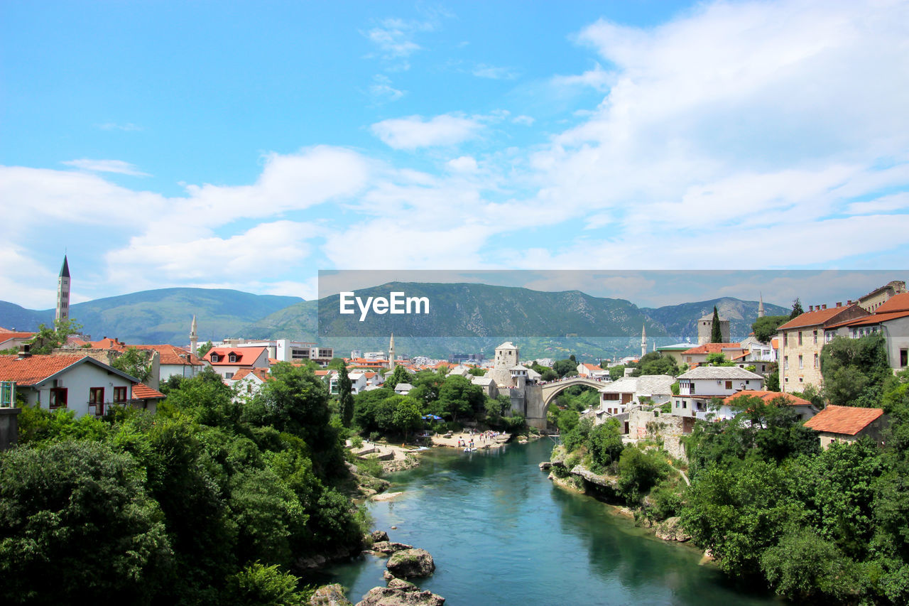 River amidst buildings in town against sky