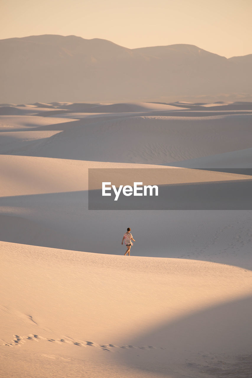 Young woman on sand dune in desert