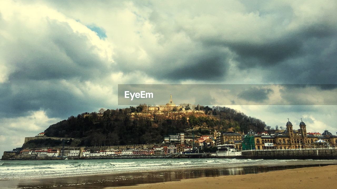 VIEW OF BUILDINGS AGAINST CLOUDY SKY