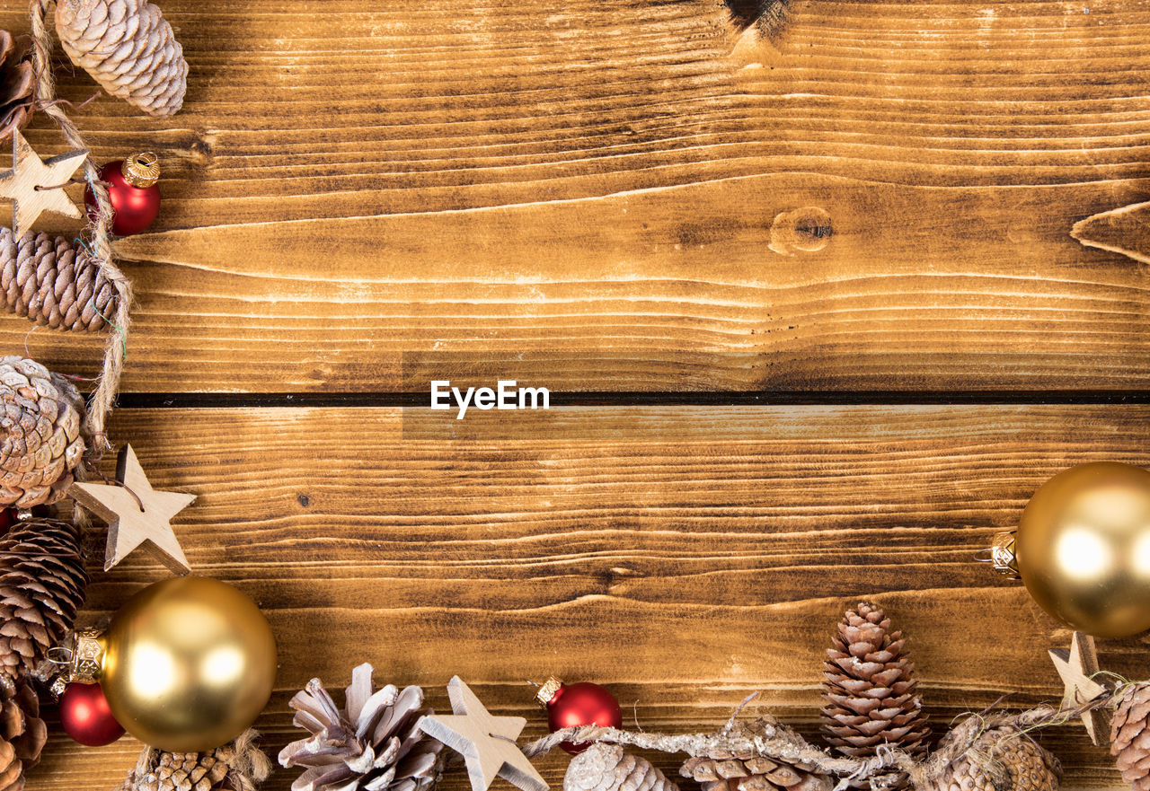 HIGH ANGLE VIEW OF CHRISTMAS DECORATIONS ON WOODEN FLOOR