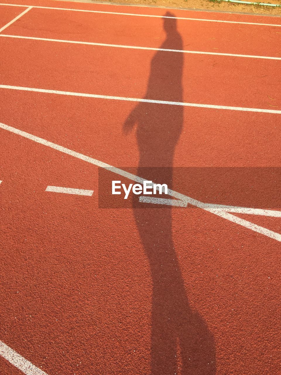Shadow of man on running track