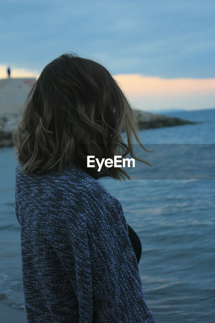 Side view of woman standing at beach