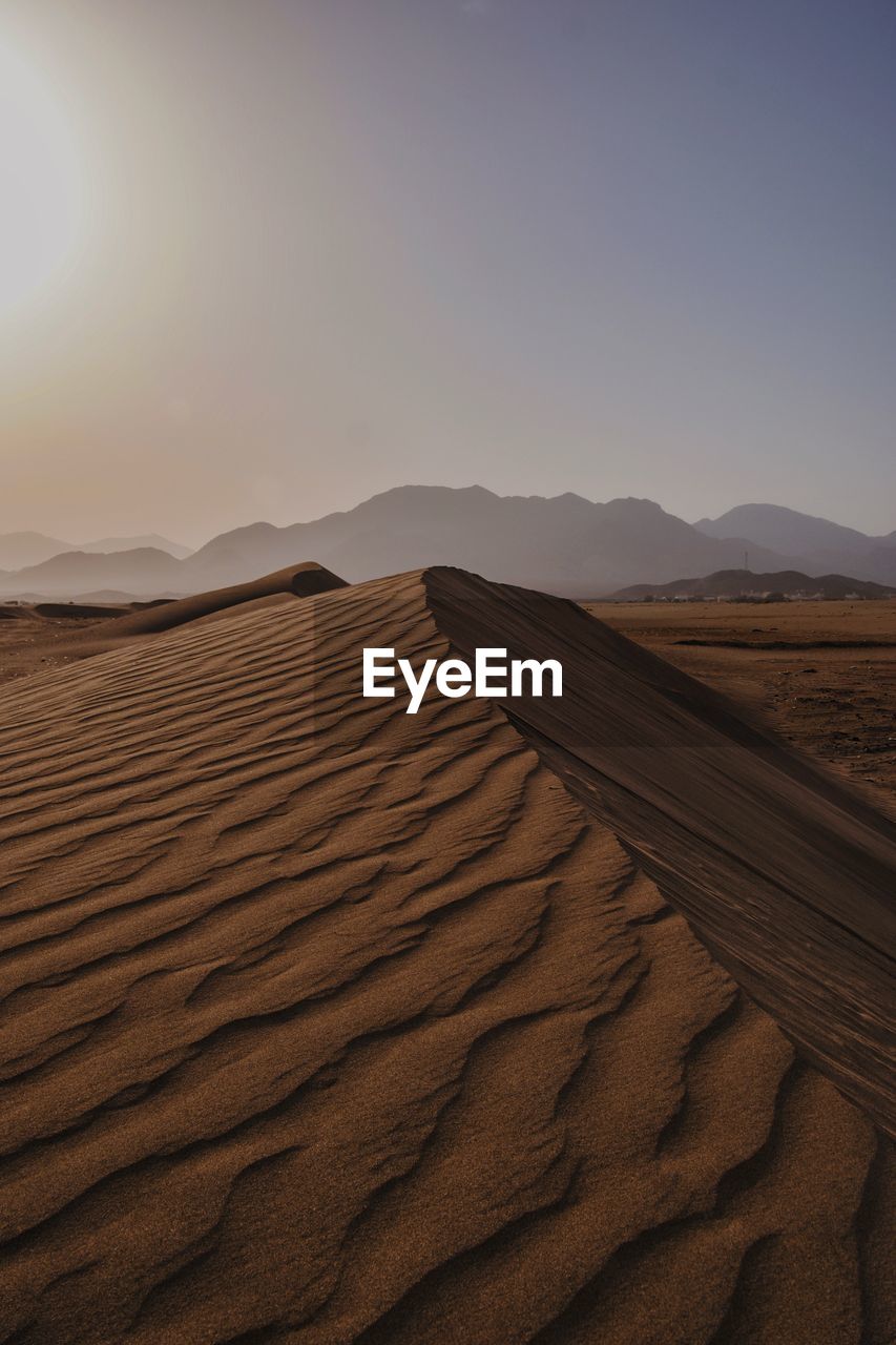 land, landscape, sand, erg, desert, environment, scenics - nature, sand dune, sky, climate, nature, beauty in nature, arid climate, travel, natural environment, tranquility, non-urban scene, no people, dry, sunlight, travel destinations, singing sand, clear sky, animal wildlife, outdoors, remote, tourism, hill, tranquil scene, sunset, horizon, sun, day, pattern, horizon over land, animal, drought, extreme terrain, grassland, sunny, animal themes, urban skyline, accidents and disasters, adventure, semi-arid