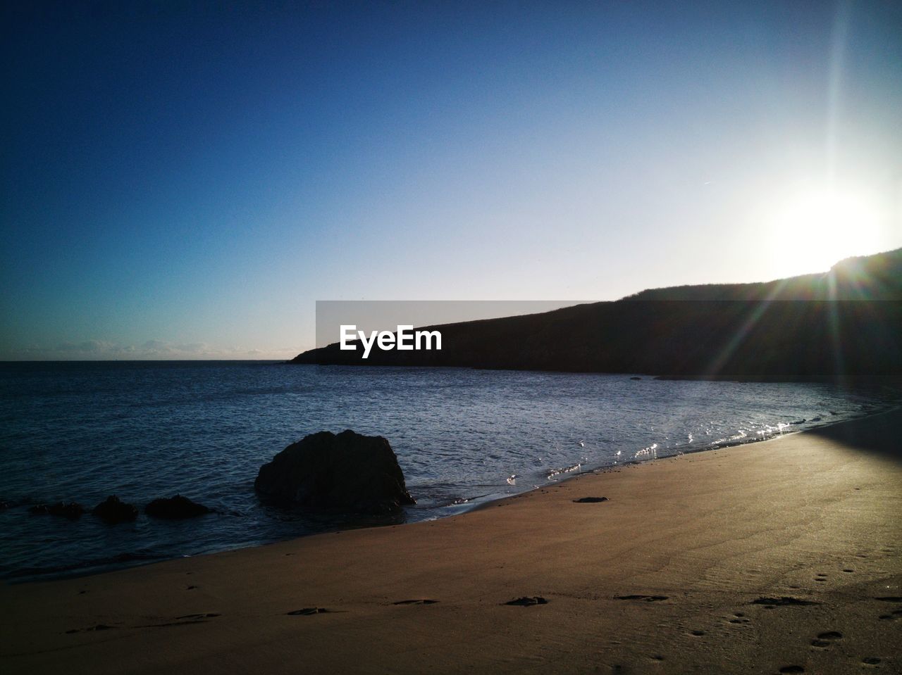 SCENIC VIEW OF BEACH AGAINST CLEAR SKY DURING SUNSET