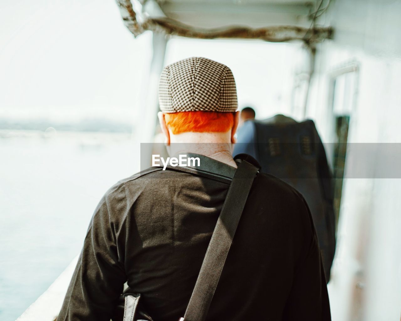Rear view of redhead man walking on boat