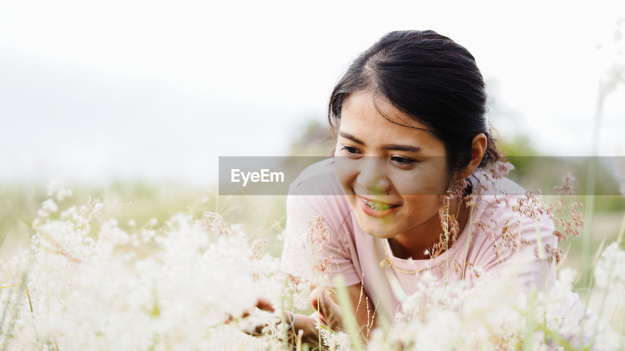 Smiling young woman by plants