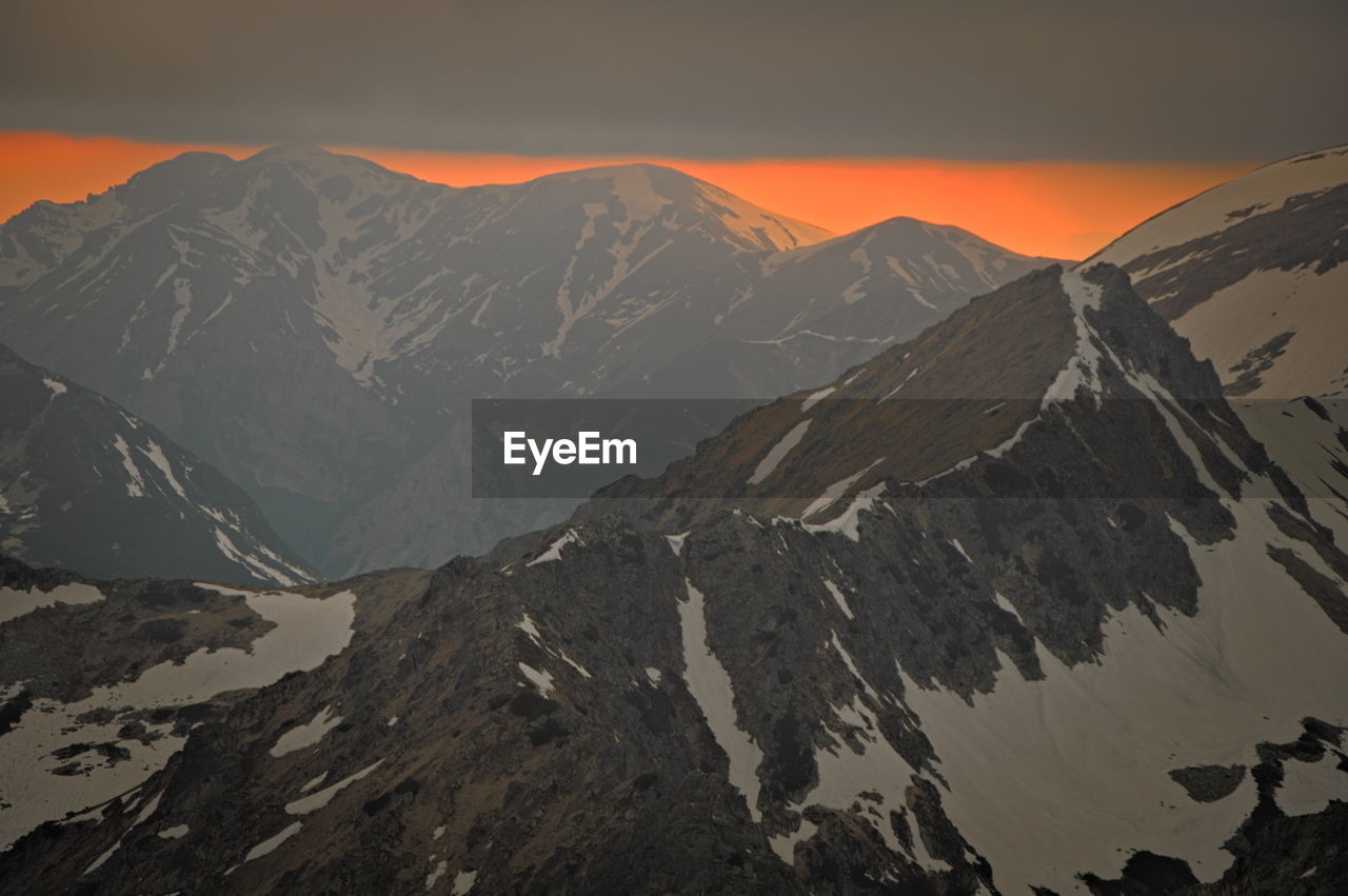 SCENIC VIEW OF SNOWCAPPED MOUNTAINS DURING SUNSET