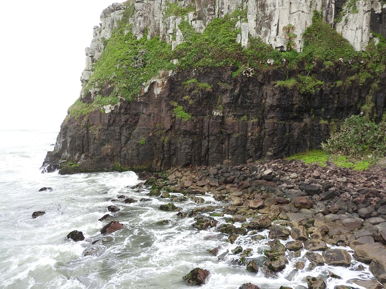 Mountain by sea against sky