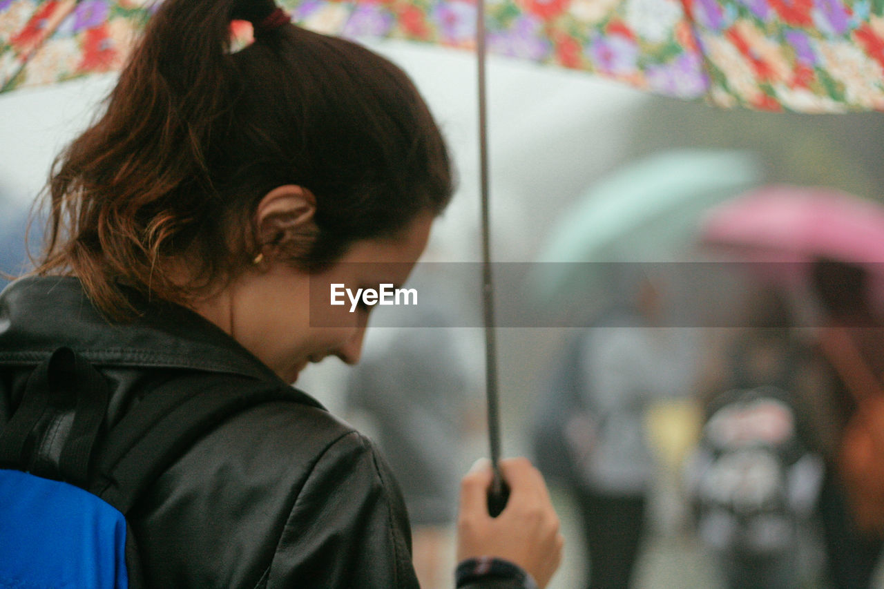 Rear view of woman holding umbrella