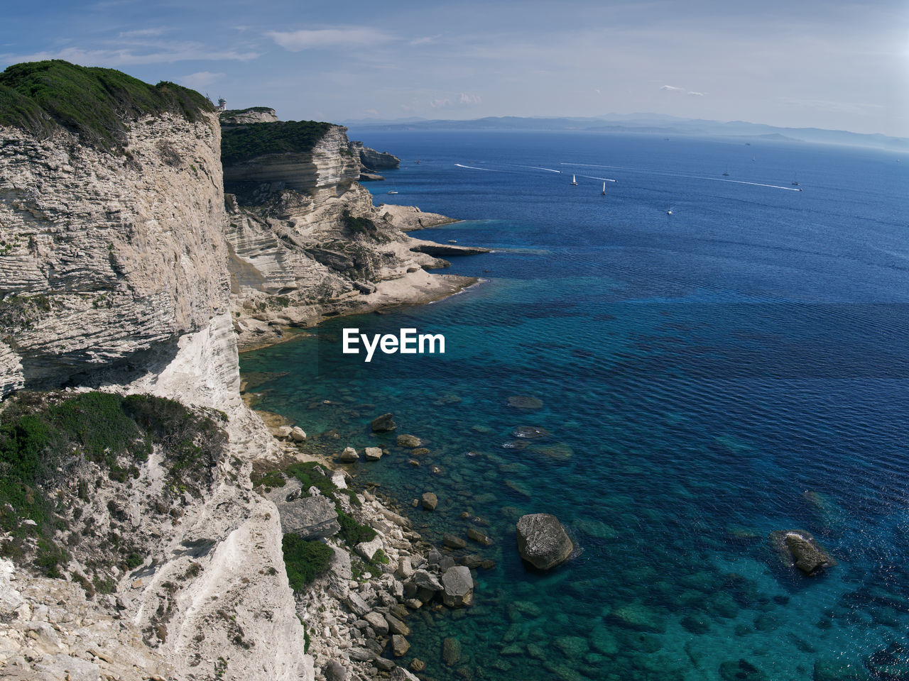 Scenic view of cliff and sea against sky