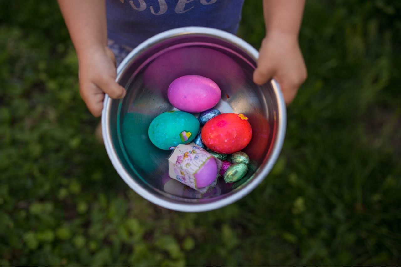 Close-up of hand holding multi colored eggs