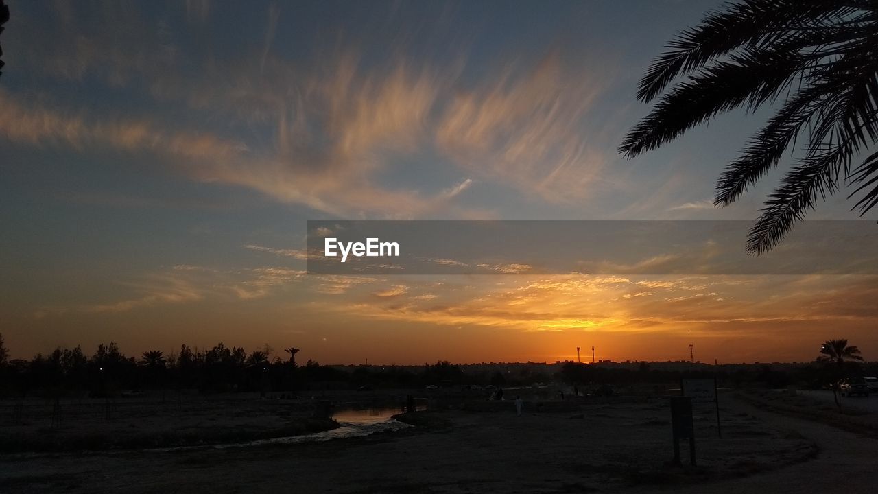 SCENIC VIEW OF SILHOUETTE BEACH AGAINST SKY DURING SUNSET