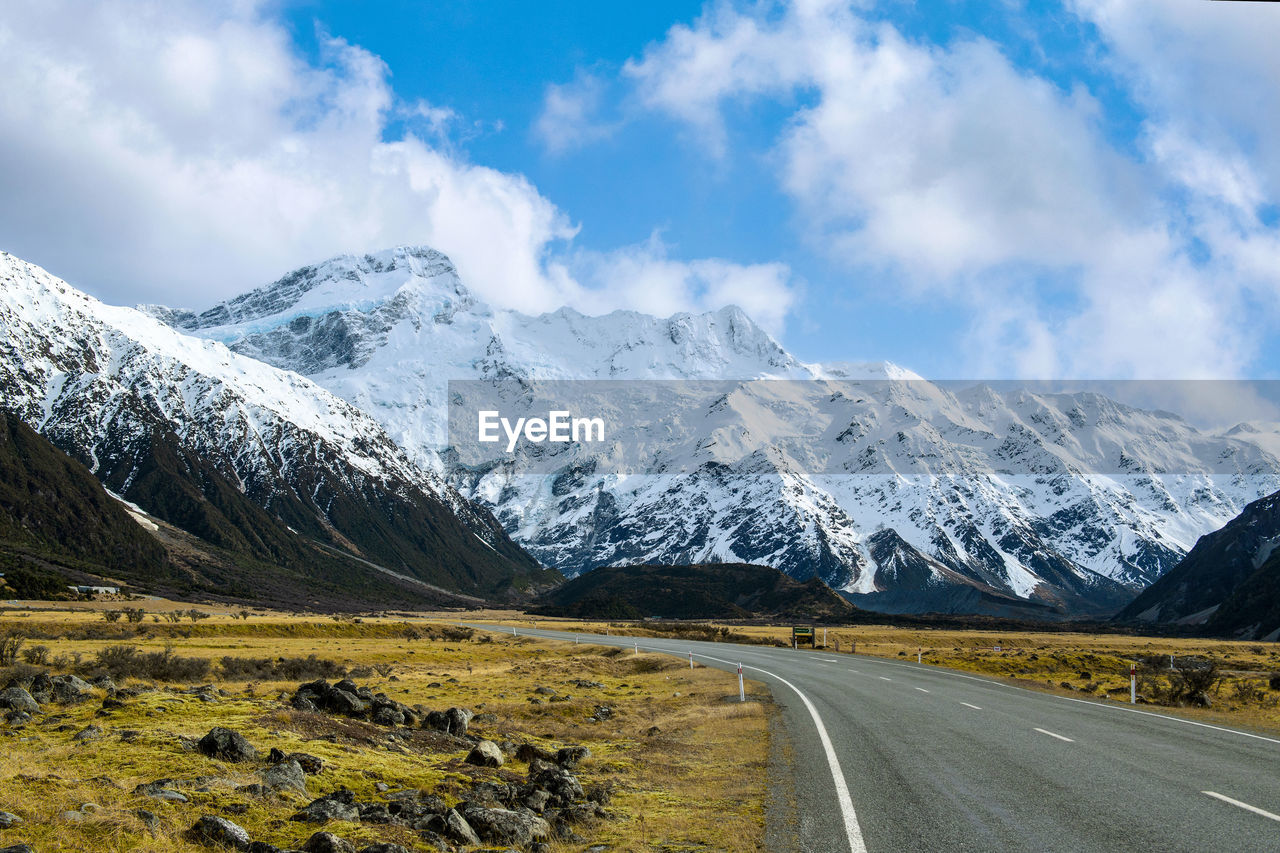 ROAD BY SNOWCAPPED MOUNTAIN AGAINST SKY