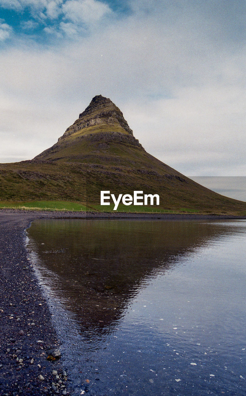 Scenic view of lake by mountain against sky
