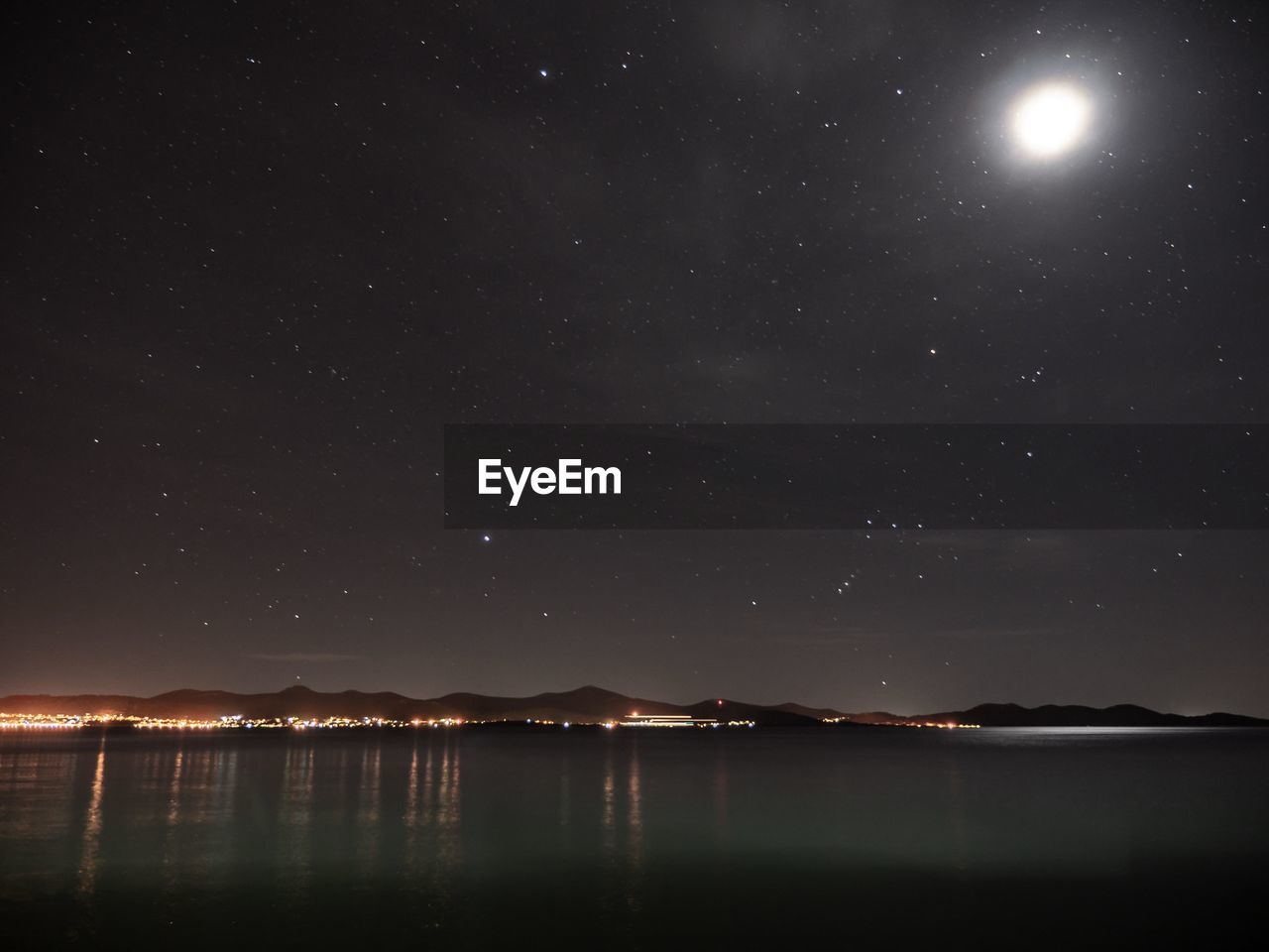 SCENIC VIEW OF LAKE AGAINST STAR FIELD AT NIGHT