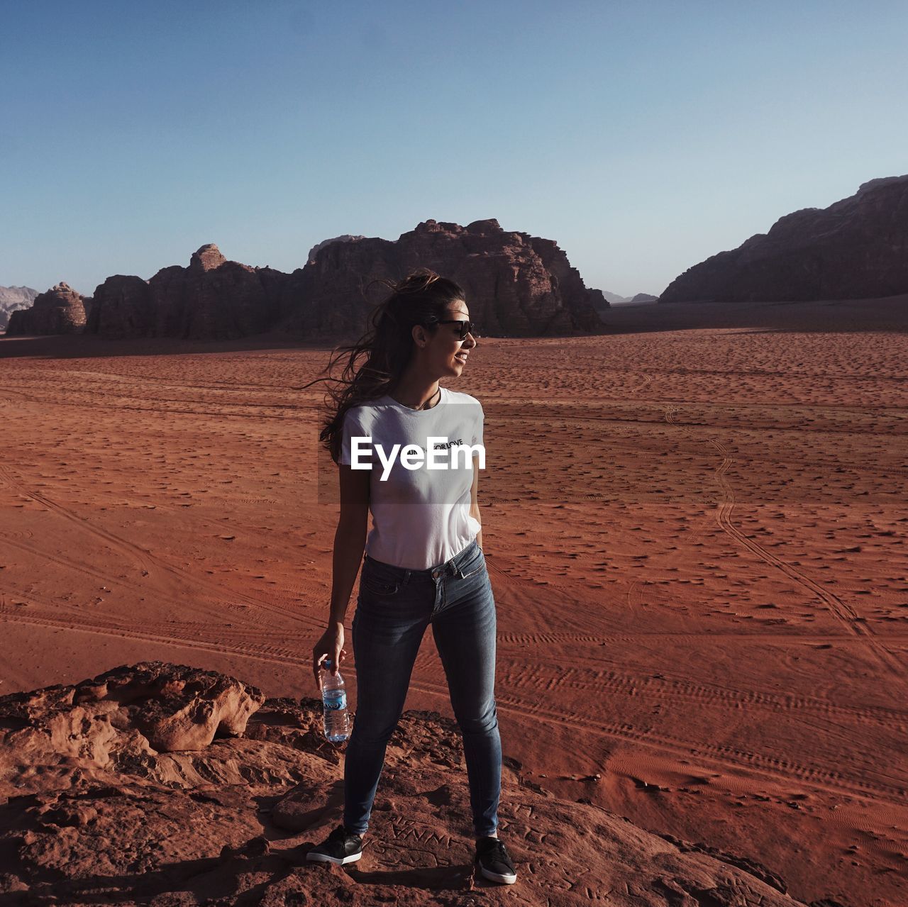 FULL LENGTH OF YOUNG WOMAN STANDING ON LAND