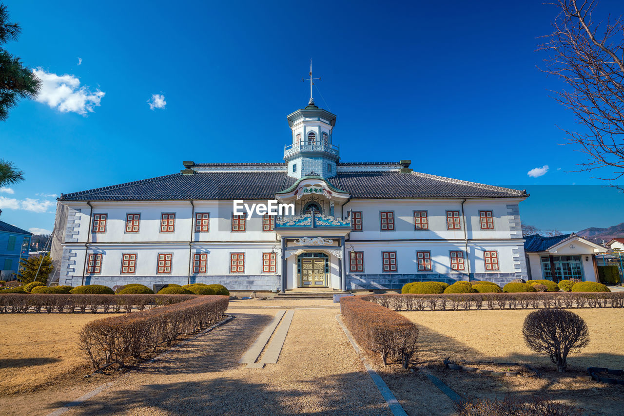 VIEW OF BUILDING AGAINST BLUE SKY