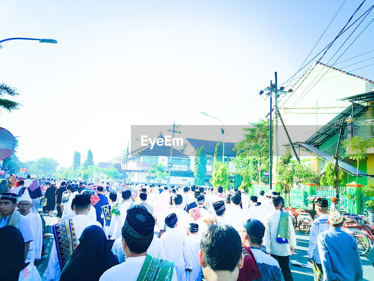 REAR VIEW OF PEOPLE ON STREET AGAINST SKY