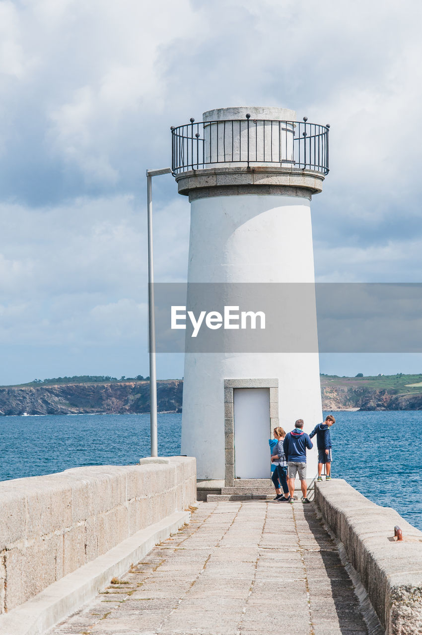 PEOPLE AT LIGHTHOUSE AGAINST SKY