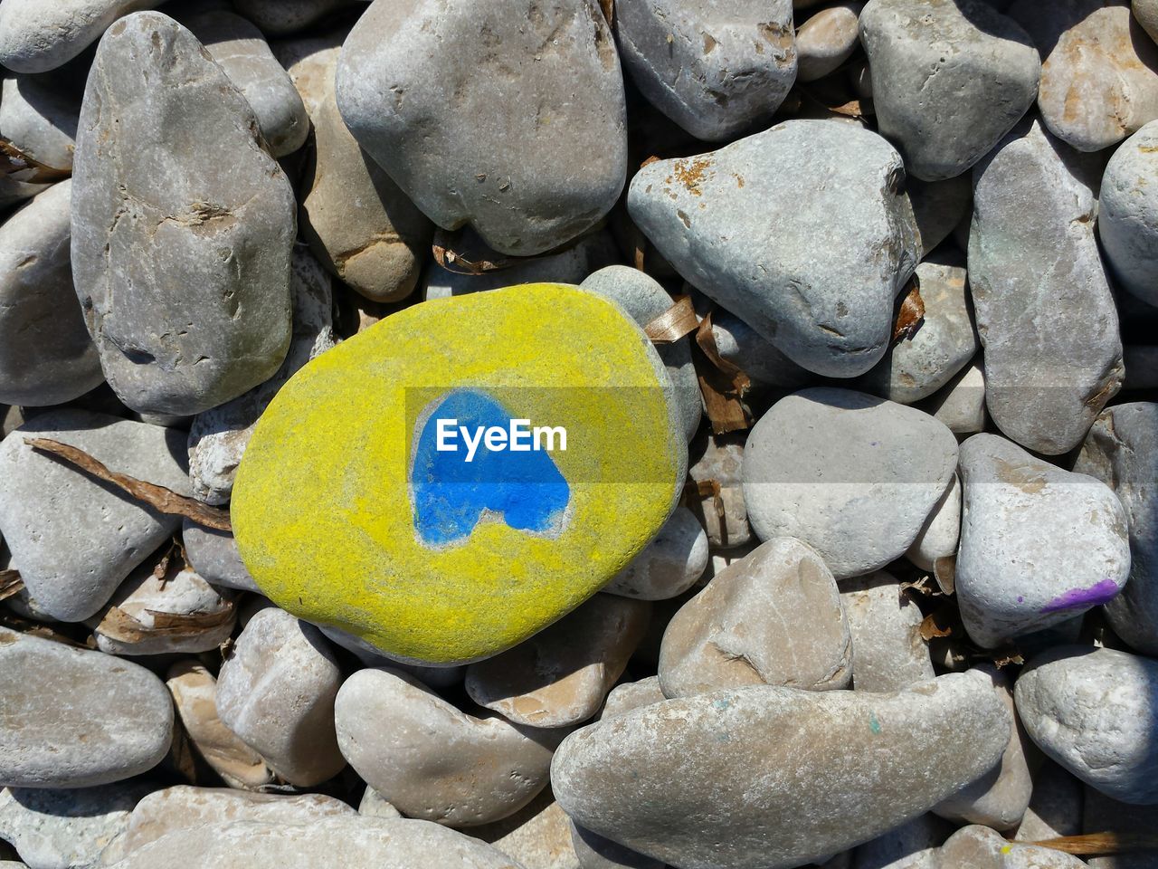 HIGH ANGLE VIEW OF PEBBLES ON ROCK