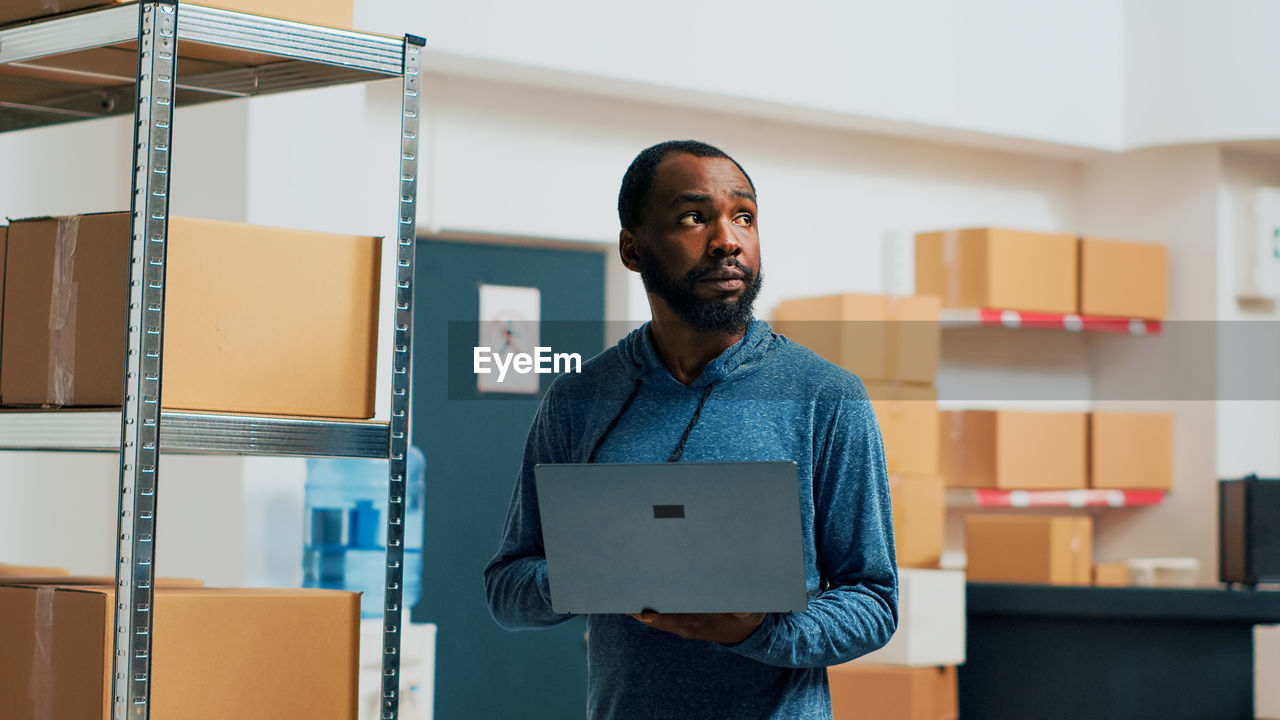 portrait of young man using digital tablet while standing in city