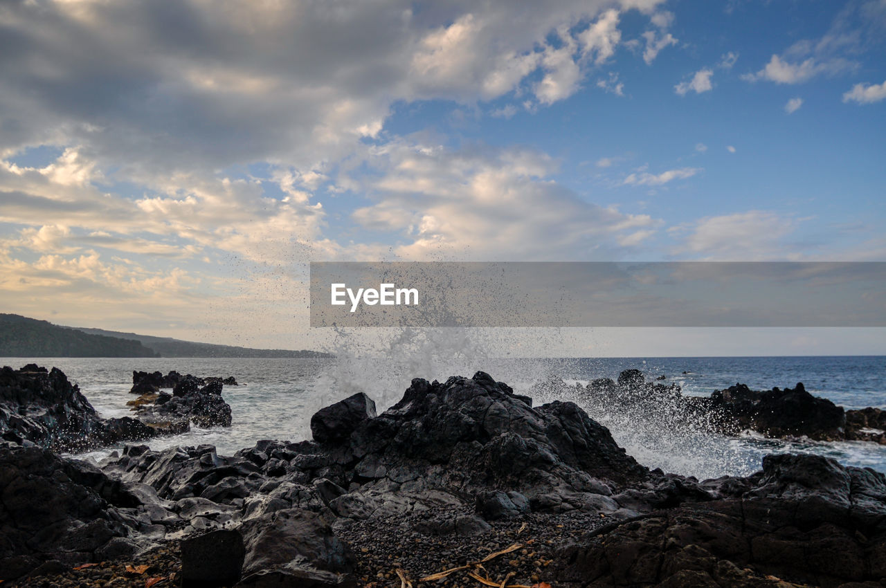 WAVES SPLASHING ON ROCKS AGAINST SEA