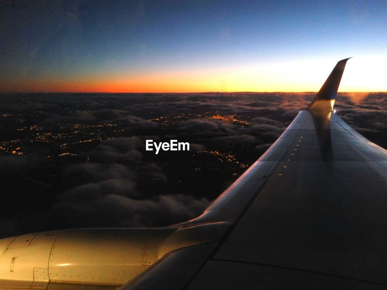 Airplane flying against sky during sunset