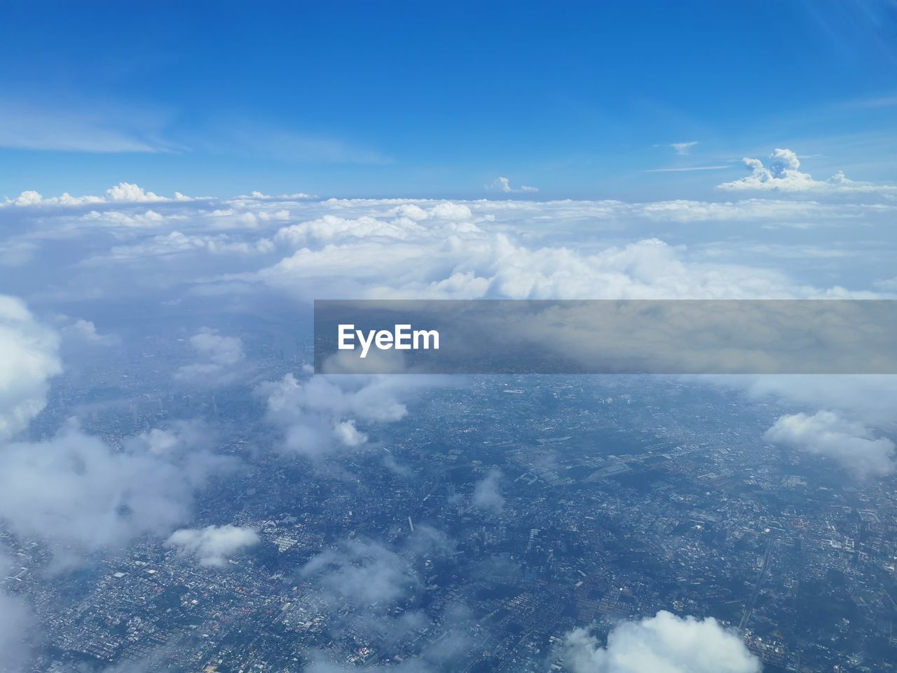 sky, cloud, aerial view, environment, blue, cloudscape, nature, scenics - nature, airplane, beauty in nature, mountain range, horizon, high up, landscape, no people, air vehicle, flying, travel, atmosphere, outdoors, high angle view, backgrounds, idyllic, tranquility, day, transportation, white, mountain, fluffy, aerial photography, wind, above, tranquil scene, sunlight, plain, copy space, fog, window, space, cold temperature, mode of transportation, land, snow, planet earth, urban skyline