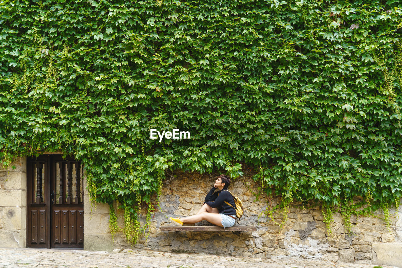 side view of man sitting on grassy field