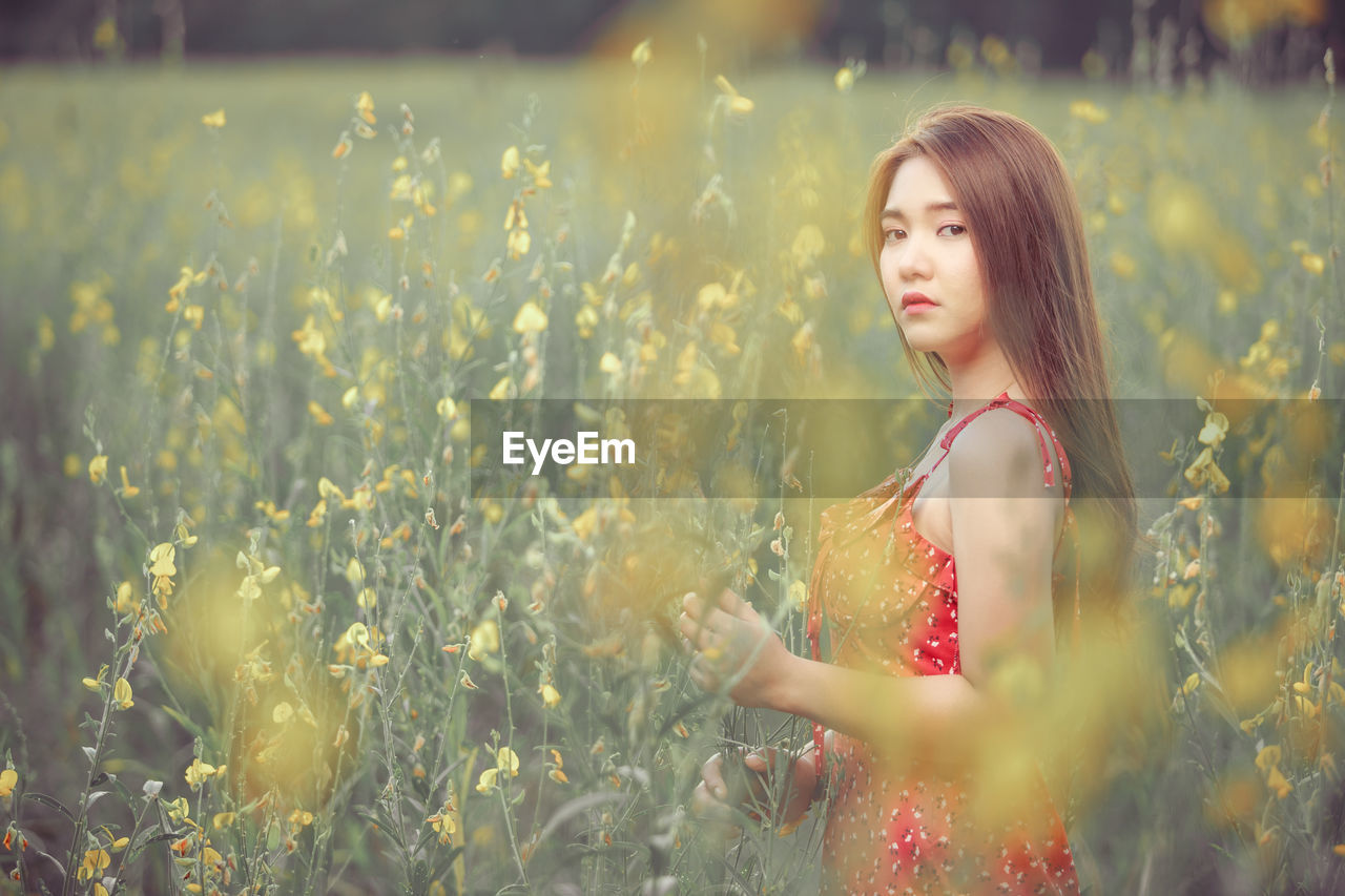 Young woman looking away in field