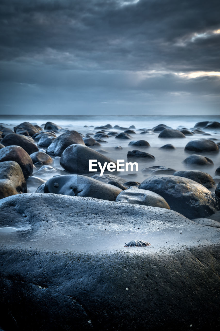 Rocks on beach against sky