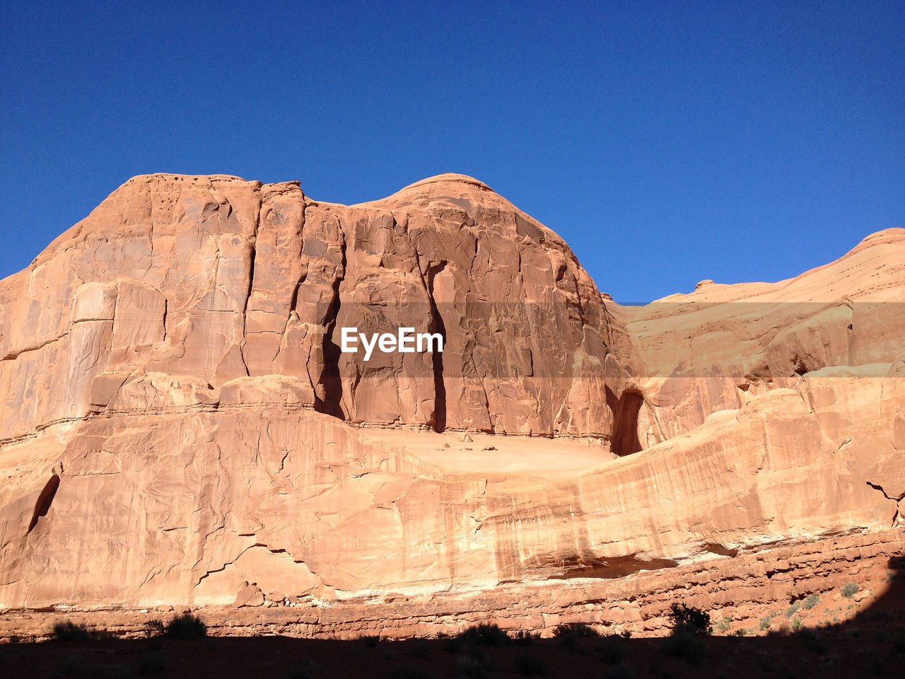 Low angle view of rock formation against clear blue sky