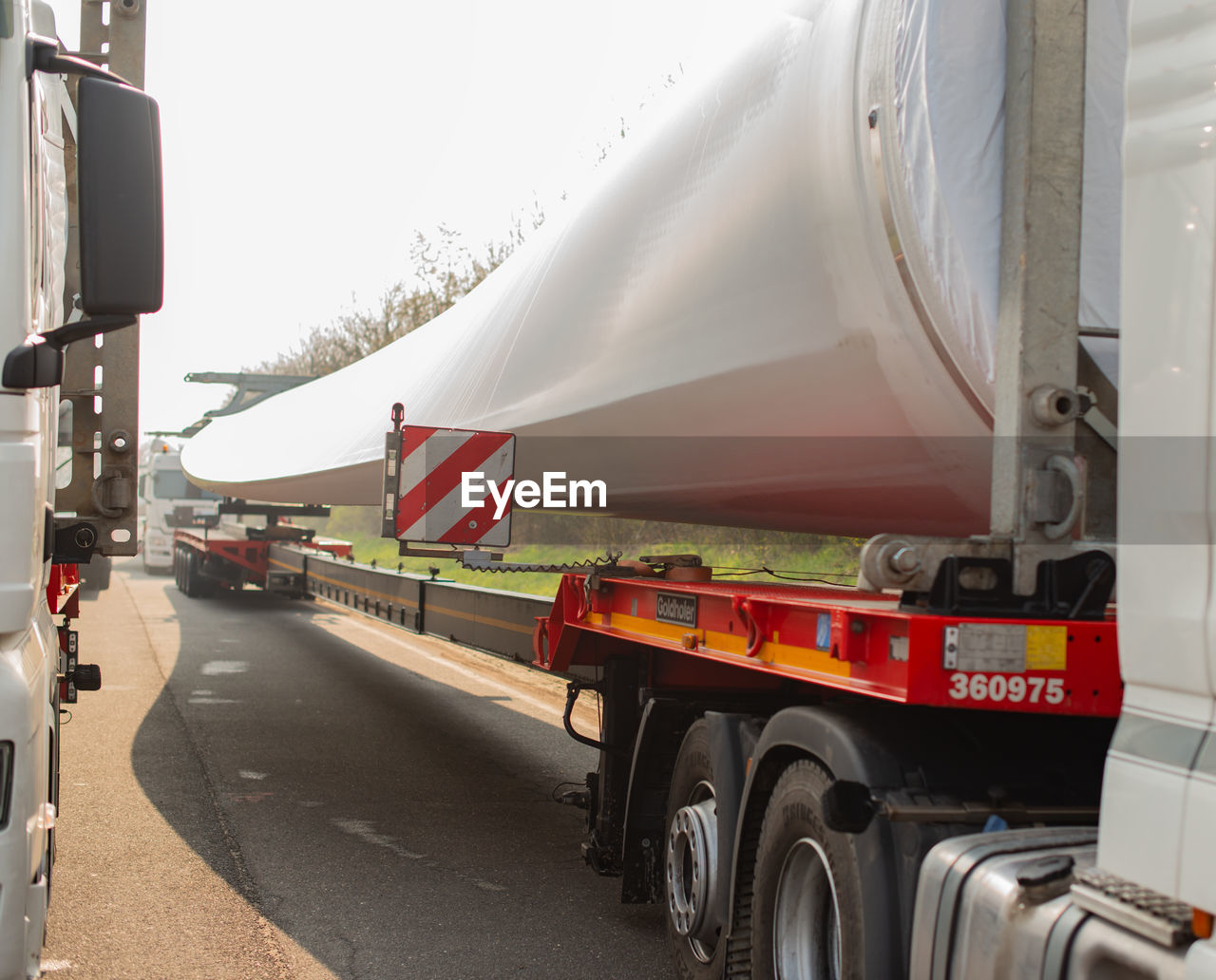 VEHICLES ON ROAD AGAINST SKY