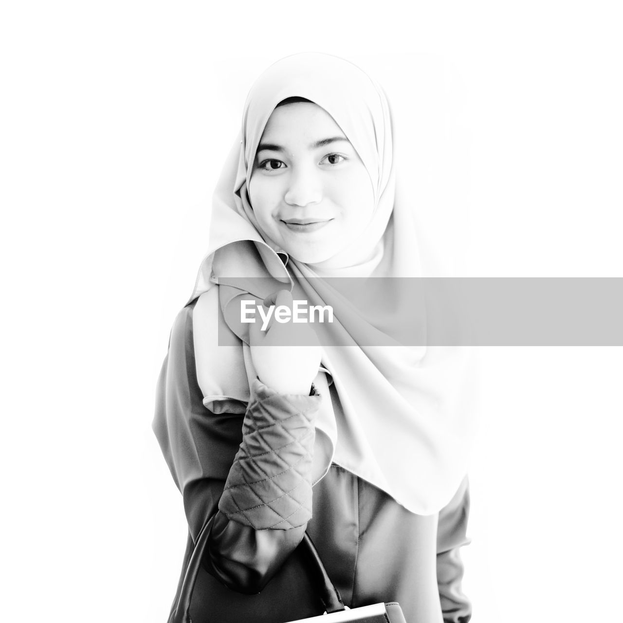 Portrait of smiling woman wearing hijab against white background