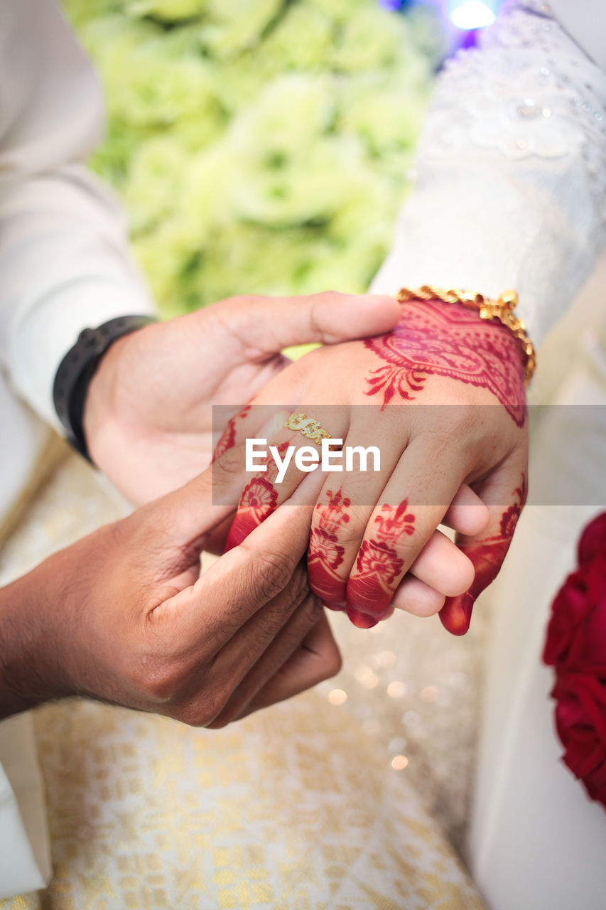 hand, adult, women, bride, finger, celebration, pink, two people, nail, event, wedding, togetherness, red, holding, flower, love, female, ceremony, petal, close-up, ring, nature, plant, newlywed, skin, positive emotion, emotion, life events, men, lifestyles, wedding dress, manicure, focus on foreground, person, clothing, wedding ceremony, indoors