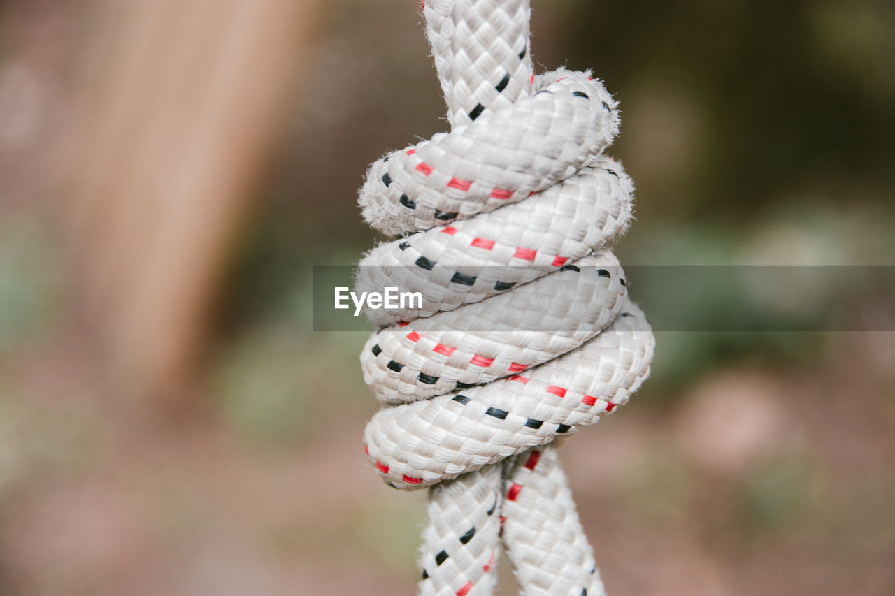 CLOSE-UP OF ROPE TIED UP ON METAL