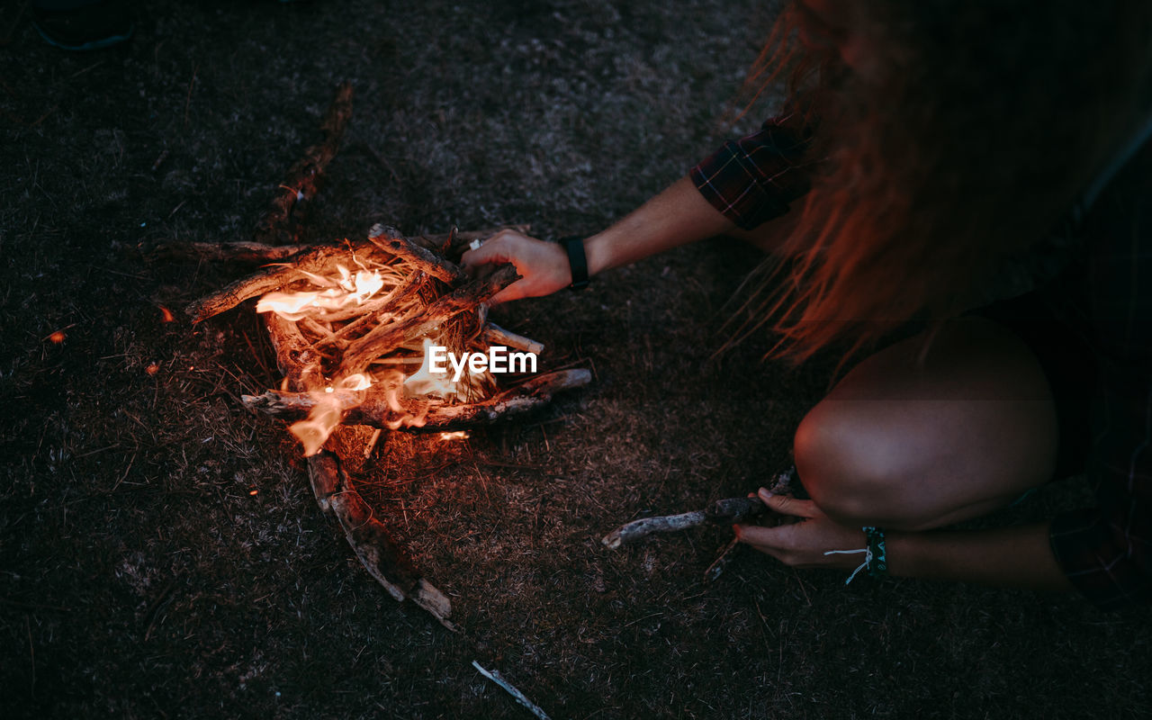 High angle view of woman starting bonfire