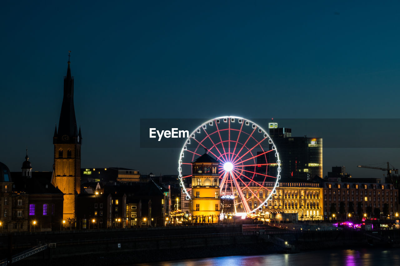 Illuminated ferris wheel at night