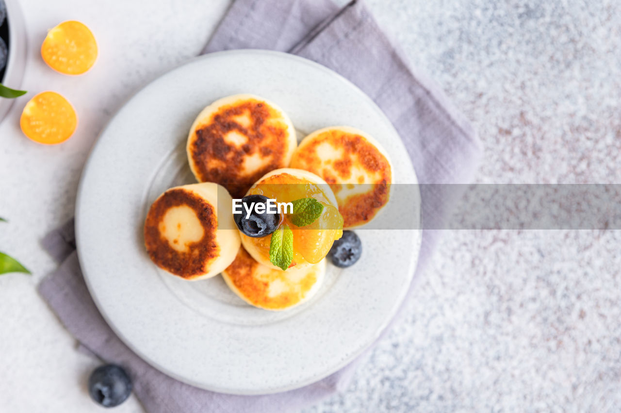 Cottage cheese pancakes, sweet curd fritters with blueberry and physalis
