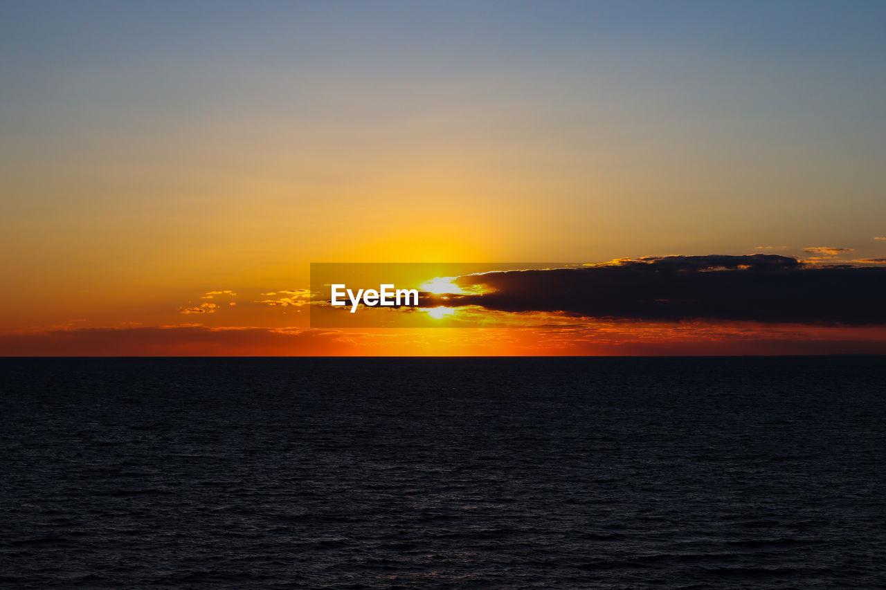 SCENIC VIEW OF SEA AGAINST SKY AT SUNSET