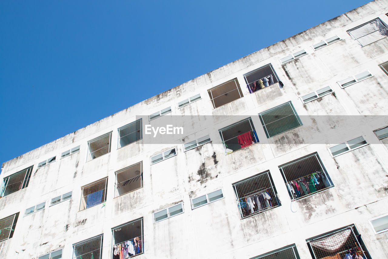 LOW ANGLE VIEW OF BUILDINGS AGAINST CLEAR BLUE SKY